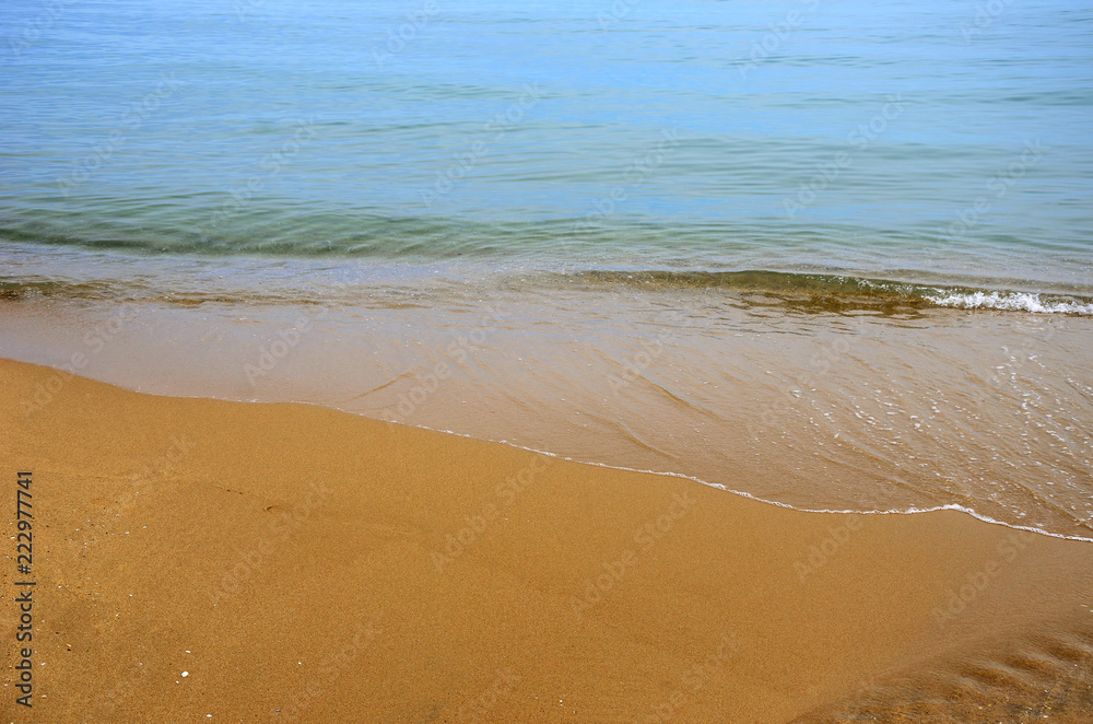 Wet sand on the beach. A part of the sea is visible. Wet sand on the beach. A part of the sea is visible.