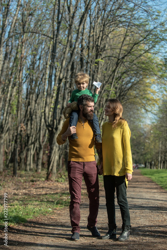 Happy family spend free time together. Mother and father piggybacking little child feel free on fresh air. Find your freedom and live your life © Volodymyr