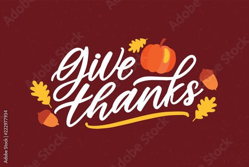 Thanksgiving day greeting card template with Give Thanks message handwritten with elegant cursive font and decorated by squash, fallen autumn leaves and acorns