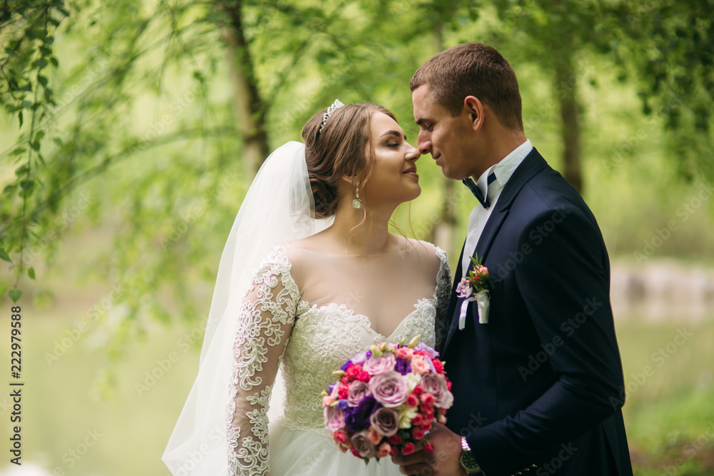 The newlyweds are walking in the park on the wedding day. The bride and groom Enjoying at the wedding day