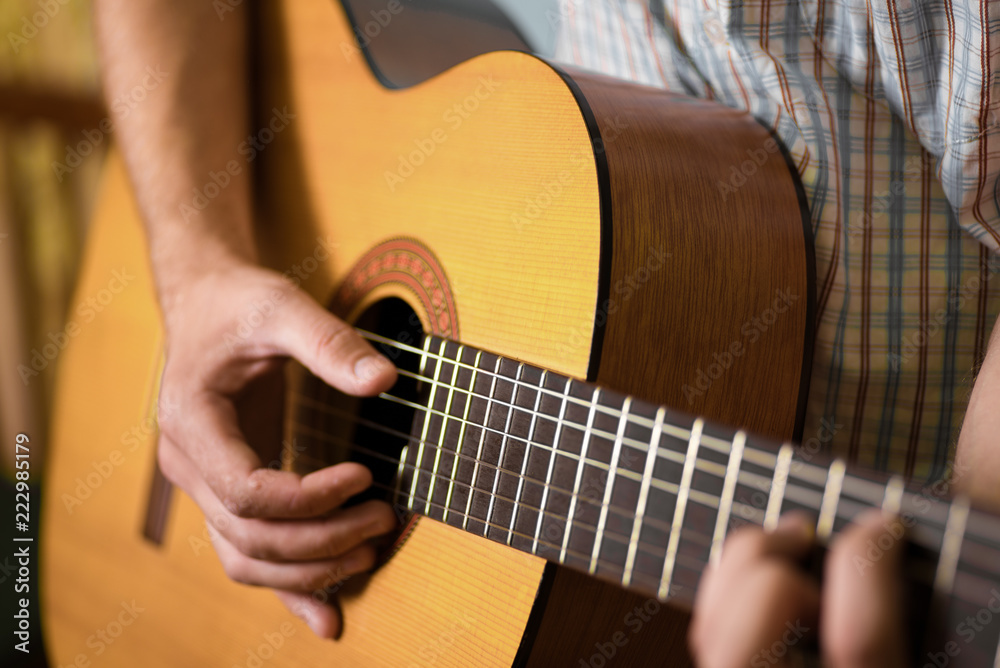 man playing classical acoustic guitar