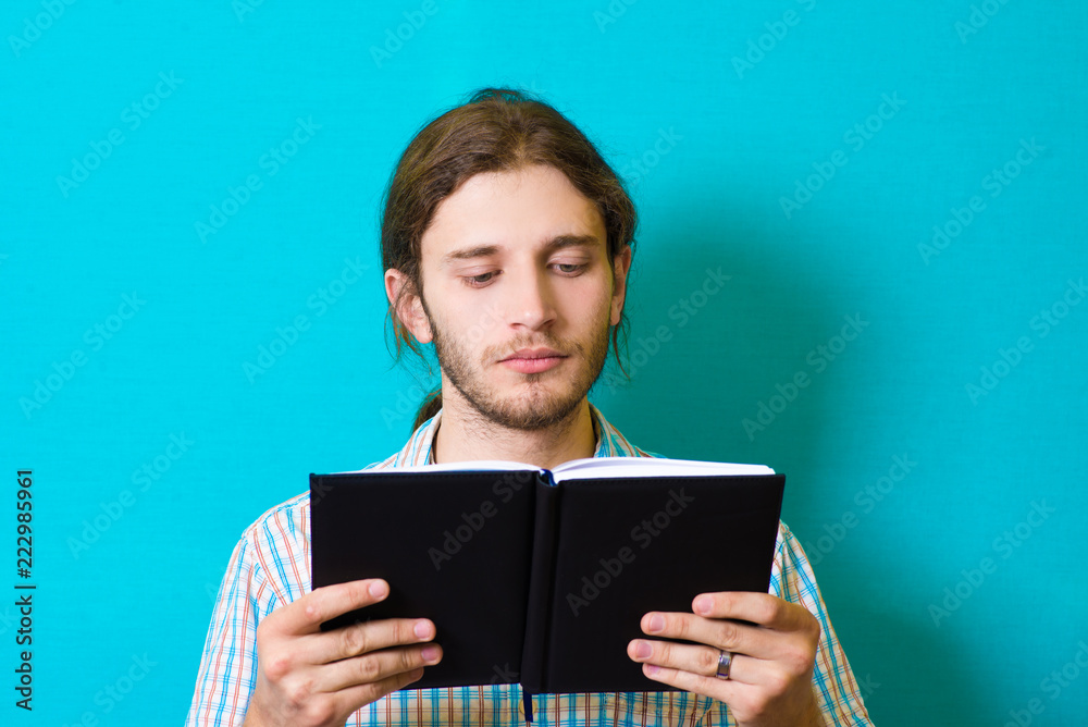 young man reading a notebook young man reading a notebook