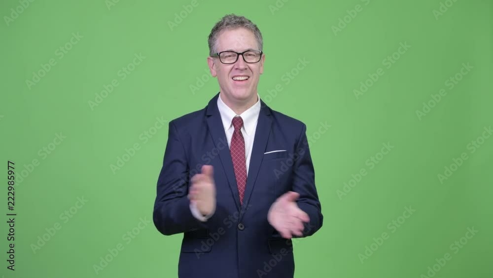 Studio shot of happy mature businessman clapping hands Studio shot of happy mature businessman clapping hands