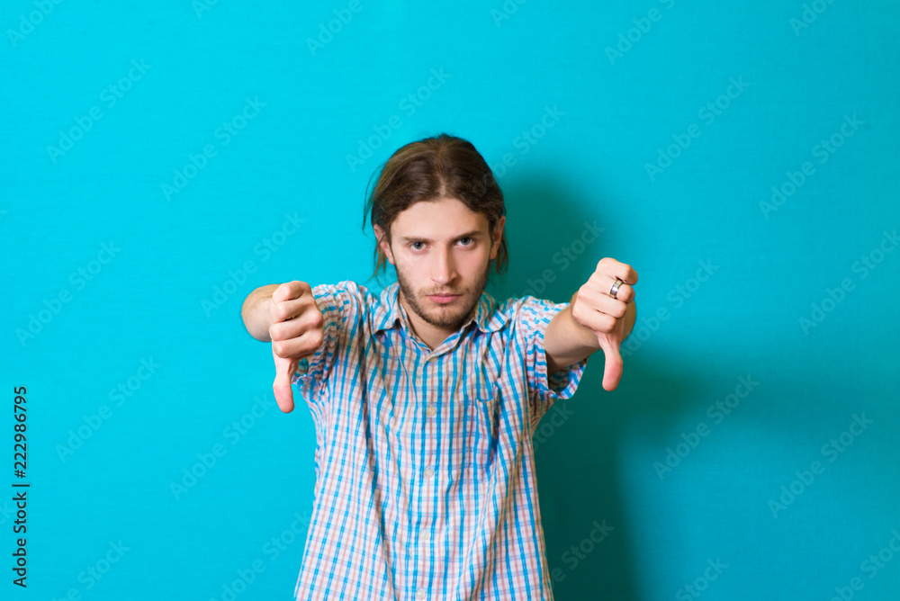 young man showing thumbs down young man showing thumbs down