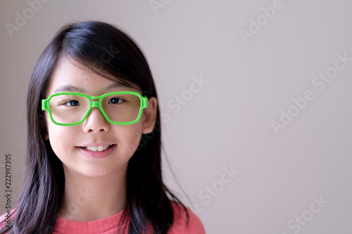 Portrait of Asian teenager girl with big green glasses © Kenishirotie