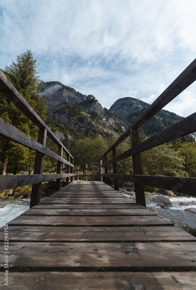 wood bridge in mountain in val di mello - sondrio italy wood bridge in mountain in val di mello - sondrio italy
