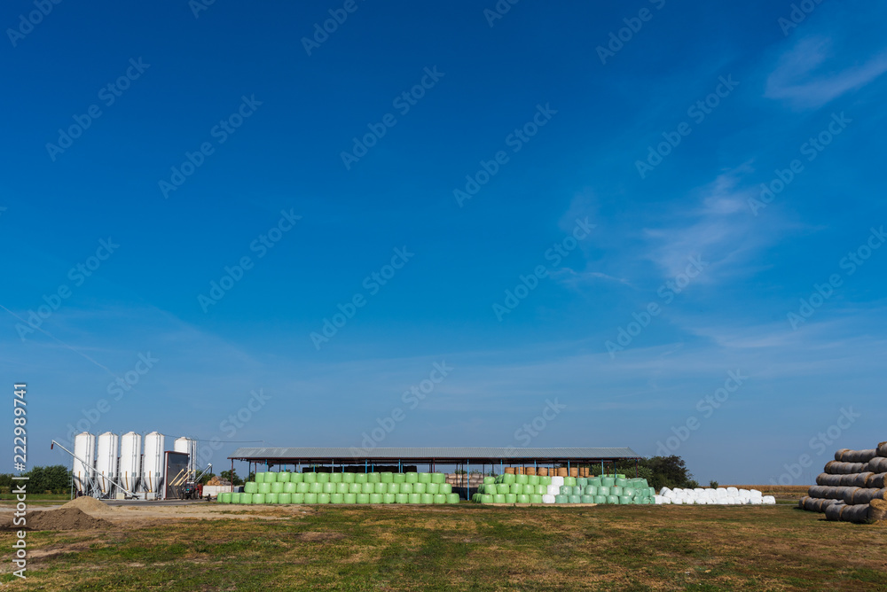 panorama of a large farm with machines and bales of hay