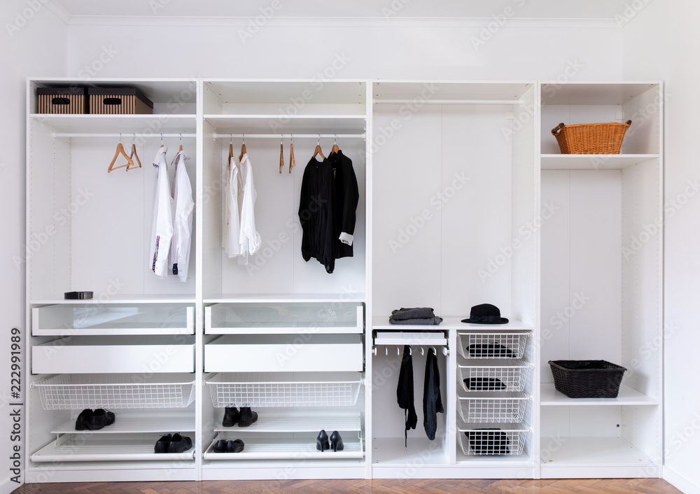 clothes hanging on rail in white wardrobe