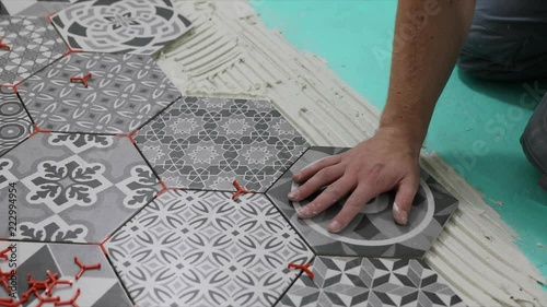 man laying hexagon floor tiles