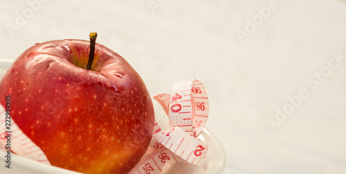 red apple with measurig tape, weigh loss concept photo