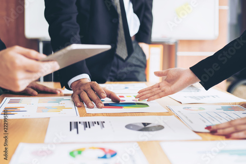 close up hand of marketing manager employee pointing at business document during discussion at meeting room , Notebook on wood table - Business concept