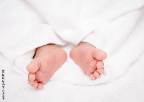 closeup baby feet on a white blanket