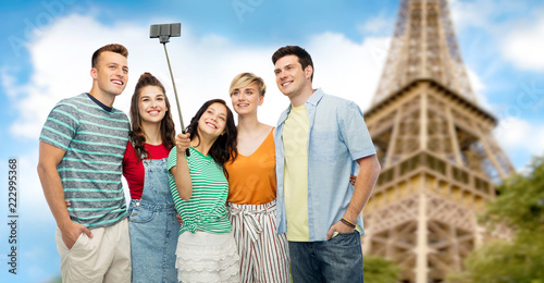 travel, tourism and technology concept - group of happy smiling friends taking selfie by smartphone over eiffel tower background