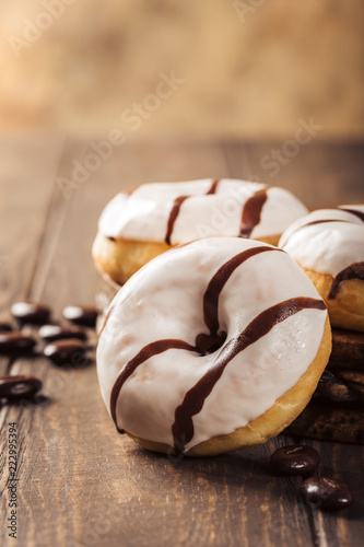Glazed mini gluten free donuts with coffee candies on wooden background. Party food concept with copy space.