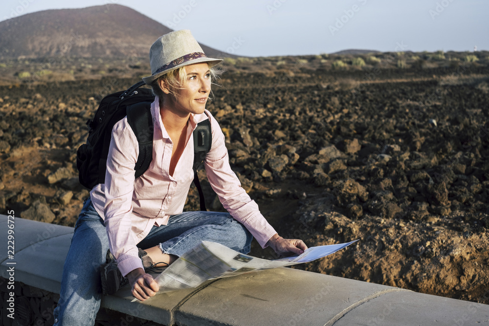 young beautiful lonely traveler woman looking at the map to choose her next destination and adventure. backpackers life and wanderlust feeling concept. cheerful nice blonde in alternative vacation