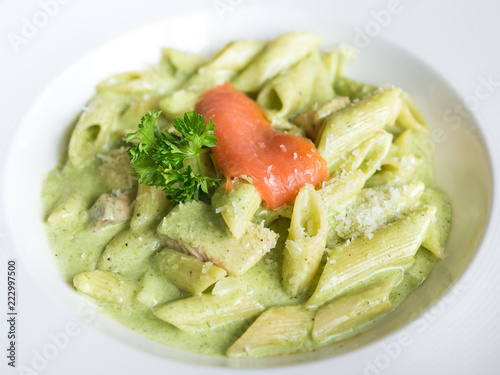 Traditional Italian Penne pasta with pesto sauce and salmon.