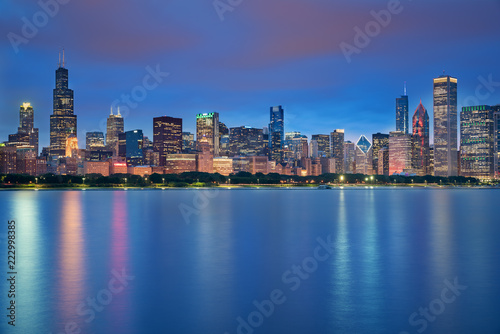 Chicago downtown skyline taken in a fantastic cloudy evening, with lights of the skyscrapers reflected in lake Michigan, Illinois, United States