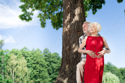 Amazing couple. Beautiful retired couple standing by the tree and looking gorgeous together
