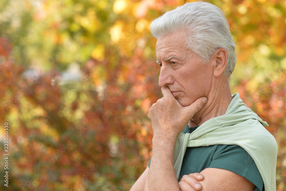Portrait of senior man posing in autumn park Portrait of senior man posing in autumn park