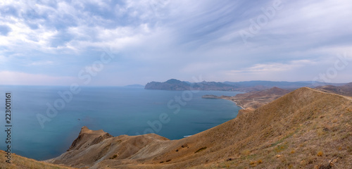 Cape Black sea in the village of Ordzhonikidze in the Crimea  in the summer with a textured sky with clouds and hilly terrain  landscape