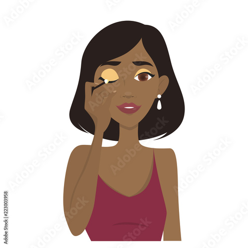 Woman applying golden eyeshadow on her eyelid