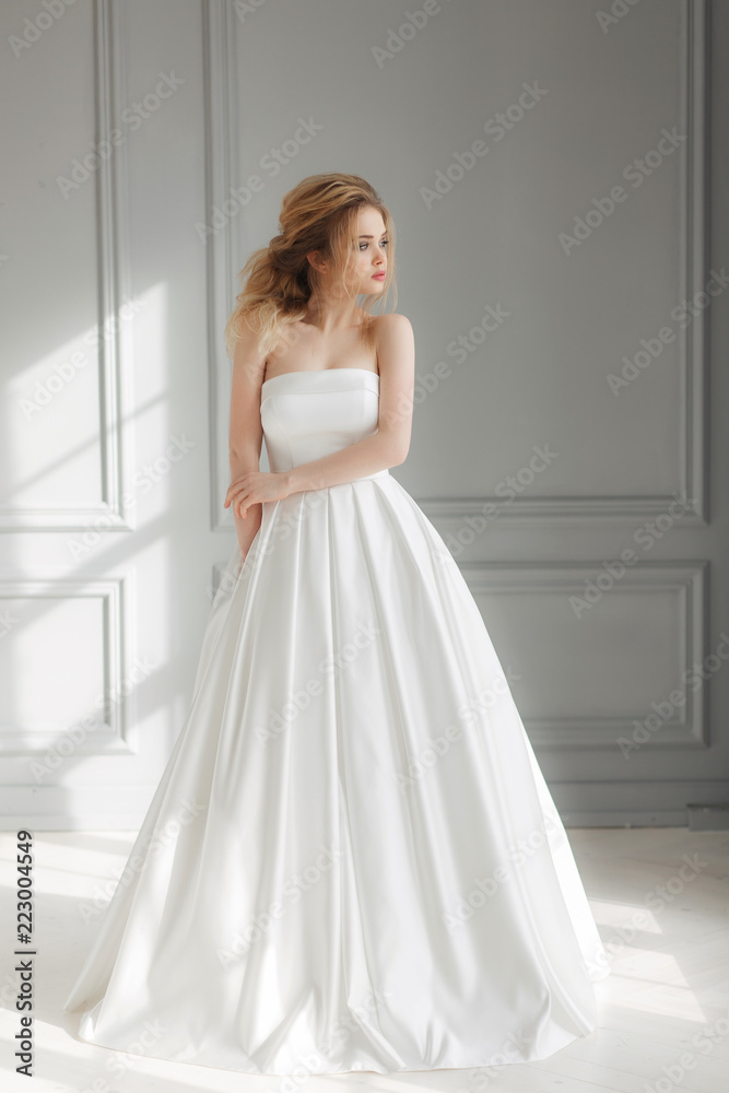 beautiful bride in simple luxurious wedding dress looking left side beautiful bride in simple luxurious wedding dress looking left side