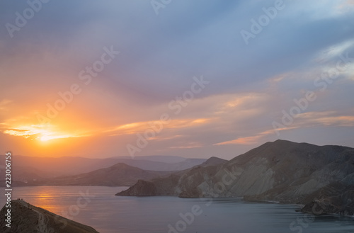 Cape Black sea in the village of Ordzhonikidze in the Crimea, in the summer with a textured sky with clouds and hilly terrain, the landscape at sunset