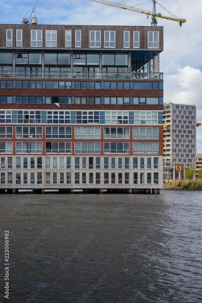 Naklejka premium View on the Amsterdam residential area from the Amstel river in a cloudy day