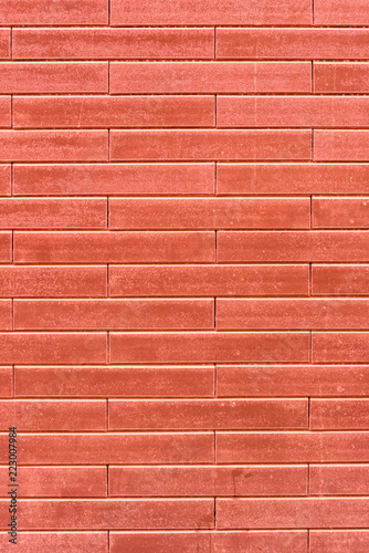 Vertical photo of the decorative texture of a red wall resembling a brick wall