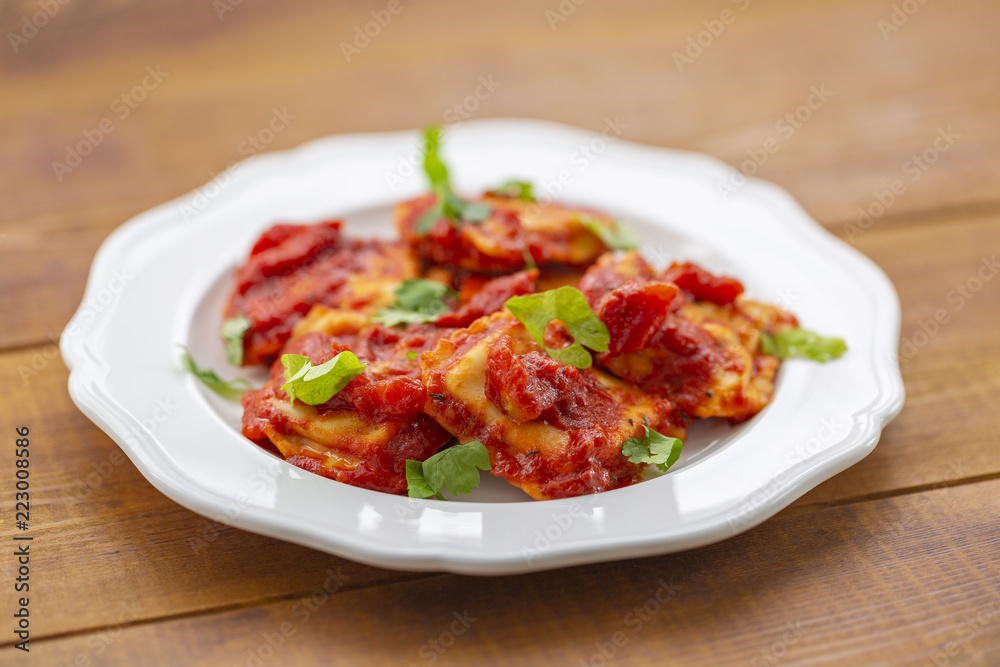 Ravioli with tomato sauce on a white plate