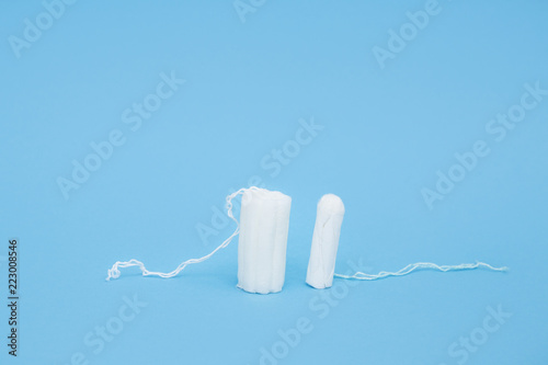 White tampons on blue background. Woman hygiene