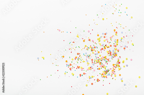 Sugar sprinkle dots on white background. Sweet decoration for cakes. Top view, copy space.