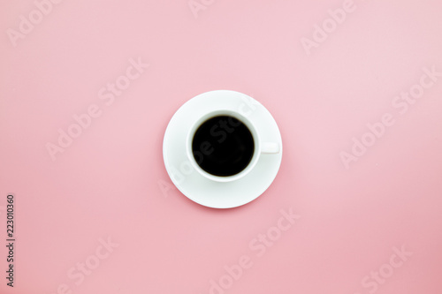 Black coffee in white cup on pink blackground pastel style copyspace flatlay topview.