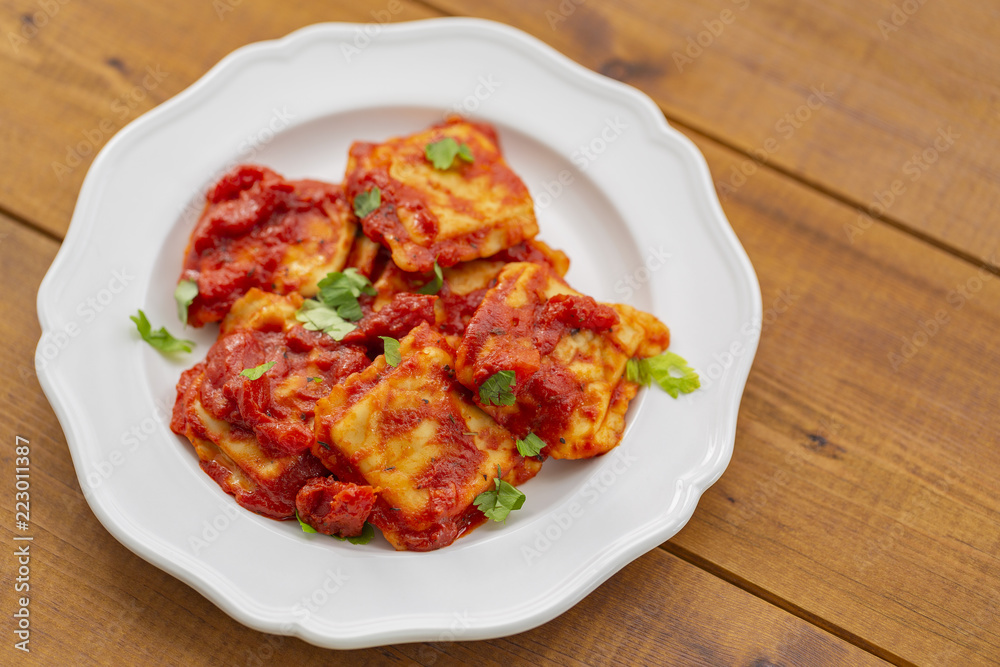 Ravioli with tomato sauce on a white plate
