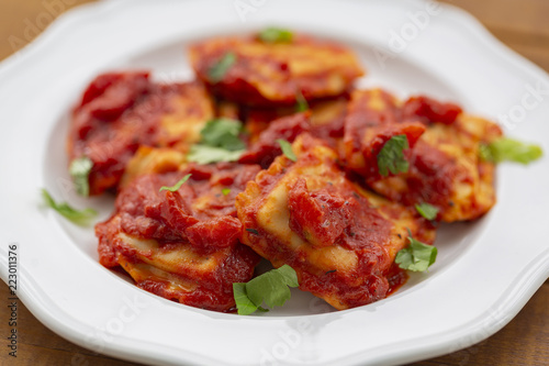 Ravioli with tomato sauce on a white plate