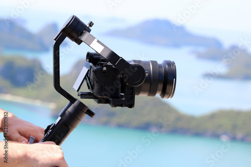 Camera Gimbal Stabilizer on top of the mountain. Ocean and blue sky background
