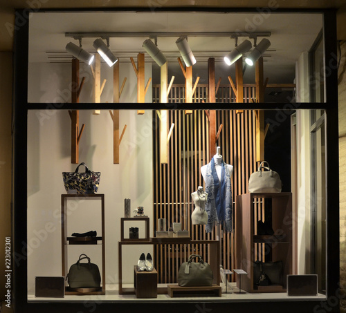 Boutique window with shoes, bags and mannequin.