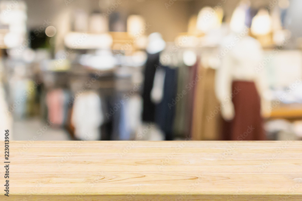 Empty wood table with woman fashionable boutique clothing store window display in shopping mall Empty wood table with woman fashionable boutique clothing store window display in shopping mall