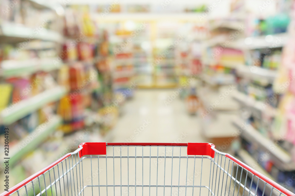 convenience store shelves interior blur background with empty supermarket shopping cart