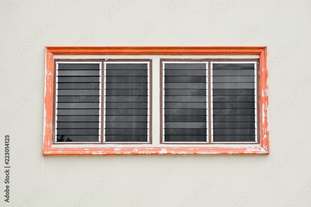orange antique glass window on white cement wall orange antique glass window on white cement wall