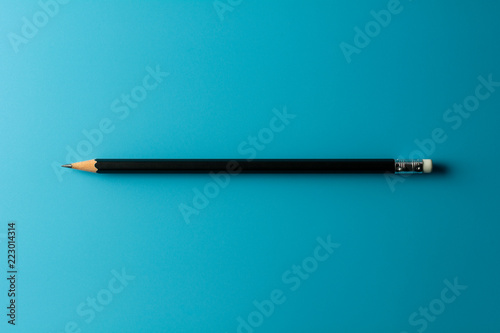 Black pencil on blue paper background. - Business concept.