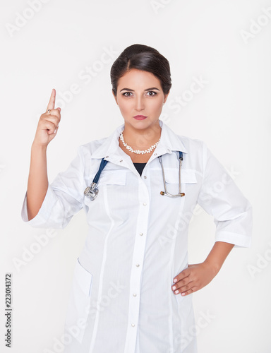 Serious woman doctor showing by finger on something on white