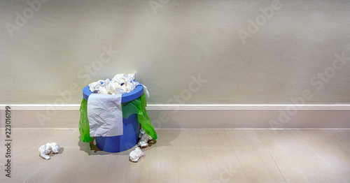 Quadro em tela Indoor trash bin overflowing with trash.