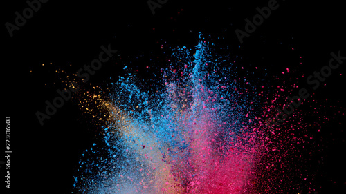 Explosion of coloured powder on black background.