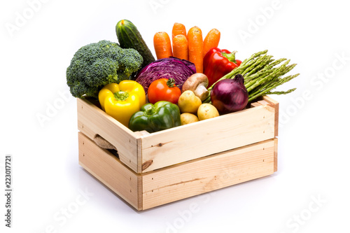 Pine box full of colorful fresh vegetables on a white background