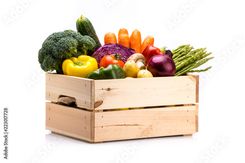 Pine box full of colorful fresh vegetables on a white background