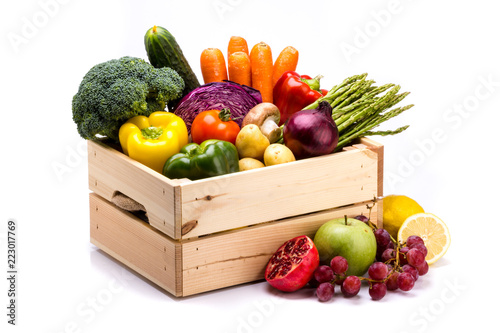 Pine box full of colorful fresh vegetables and fruits on a white background