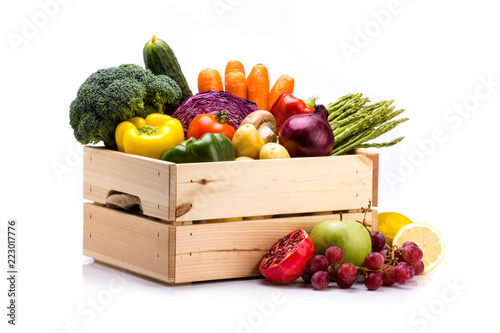 Pine box full of colorful fresh vegetables and fruits on a white background