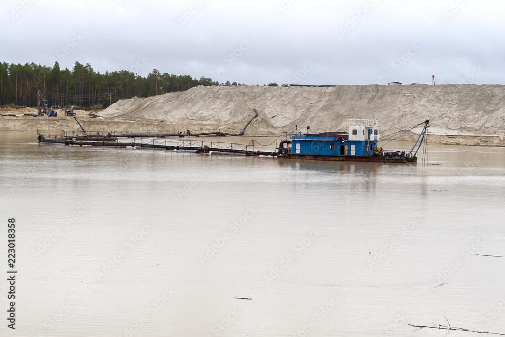 The dredger extracts sand from the quarry in the forest.