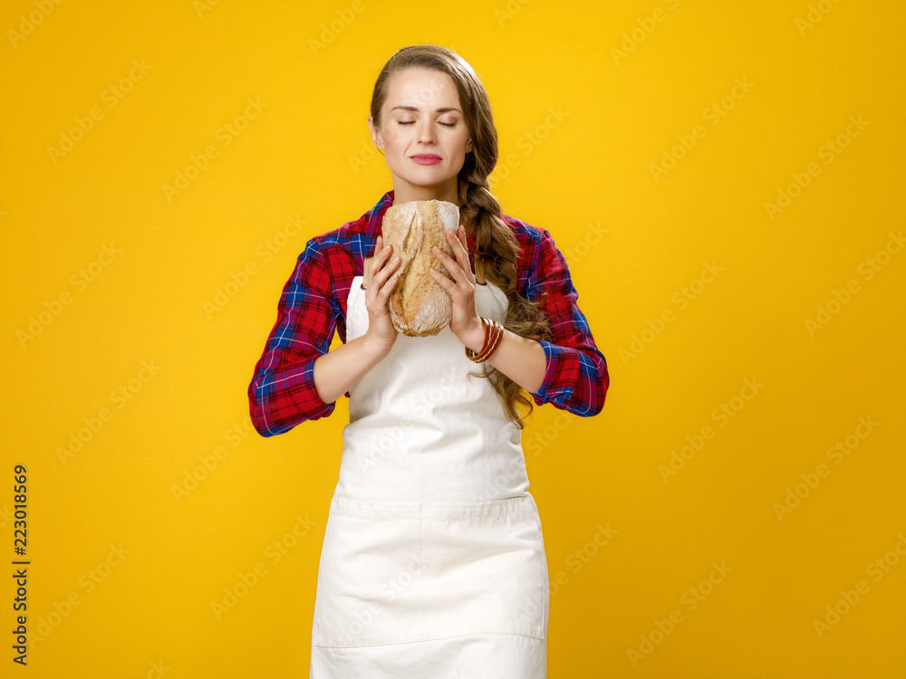 modern woman farmer on yellow background enjoying fresh bread modern woman farmer on yellow background enjoying fresh bread